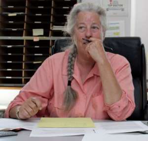 Leanna Standish sitting at a desk in a salmon shirt