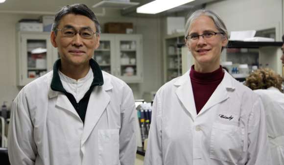 Two individuals in white lab coats in a lab