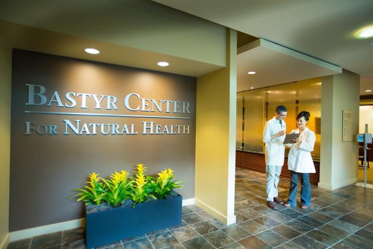 two doctors talking in front of Bastyr Center for Natural Health sign