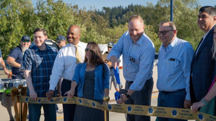 team of people cutting ribbon