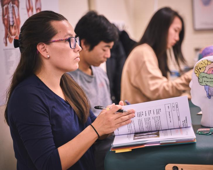 student with acupuncture textbook