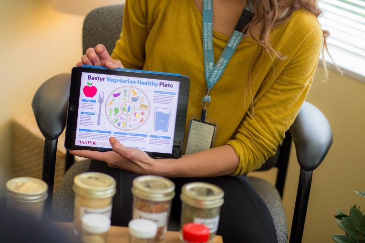 woman sharing a tablet screen with nutrition information