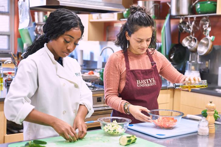 two students cooking in Bastyr kitchen