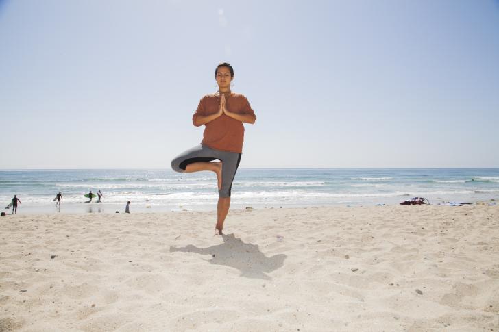 woman doing yoga on beach