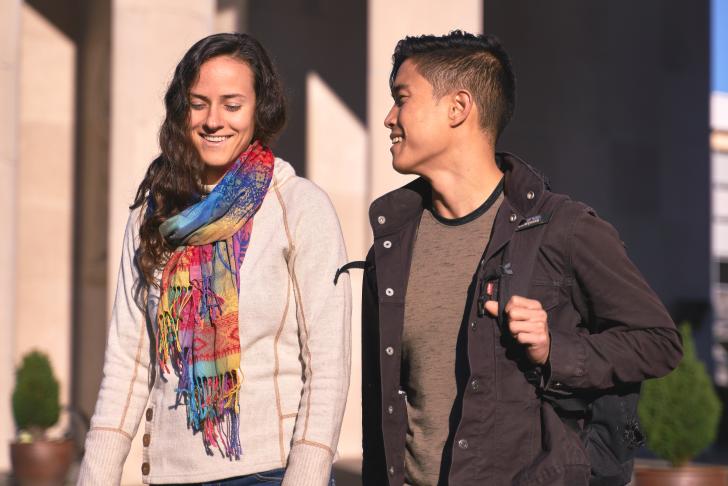 two students walking by pillars