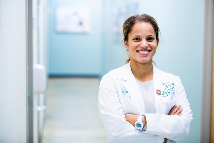 doctor looking at camera smiling in hallway