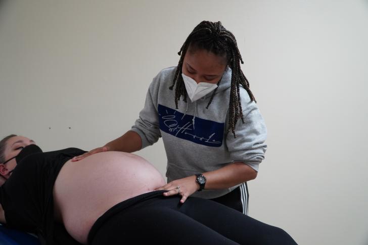 student performing exam on pregnant person