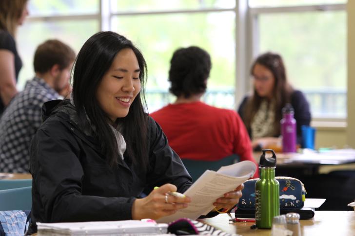 student studying at table smiling