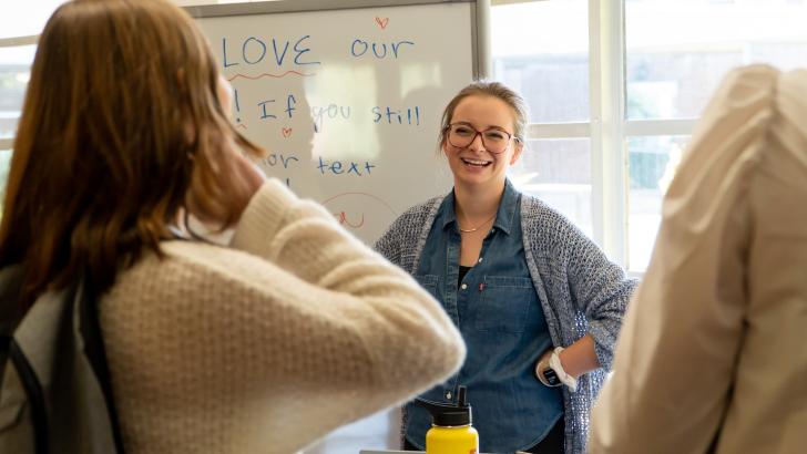 student smiling at table