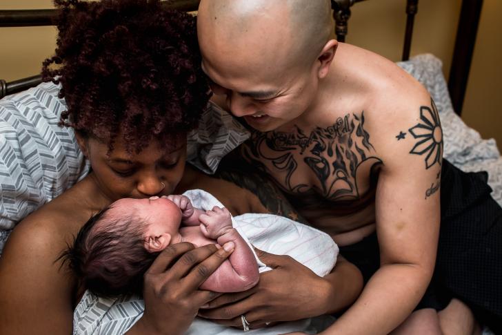 postpartum couple holding their newborn