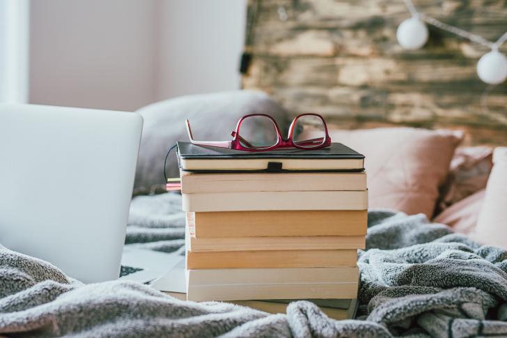stack of books and glasses sitting on top