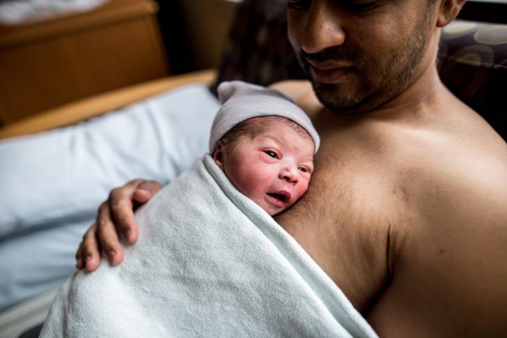 man holding newborn baby