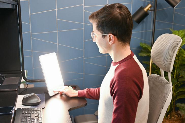 person sitting at desk with light therapy lamp