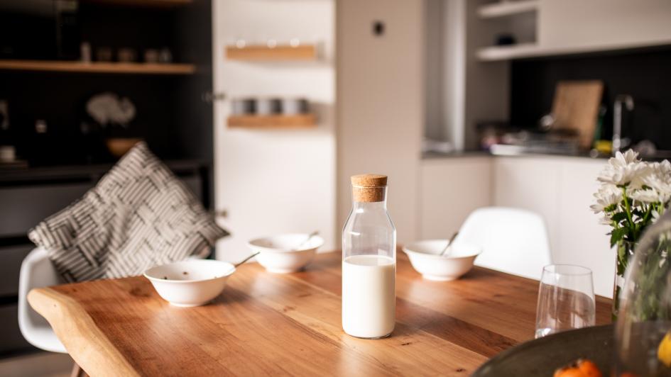 milk sitting on wooden table in kitchen