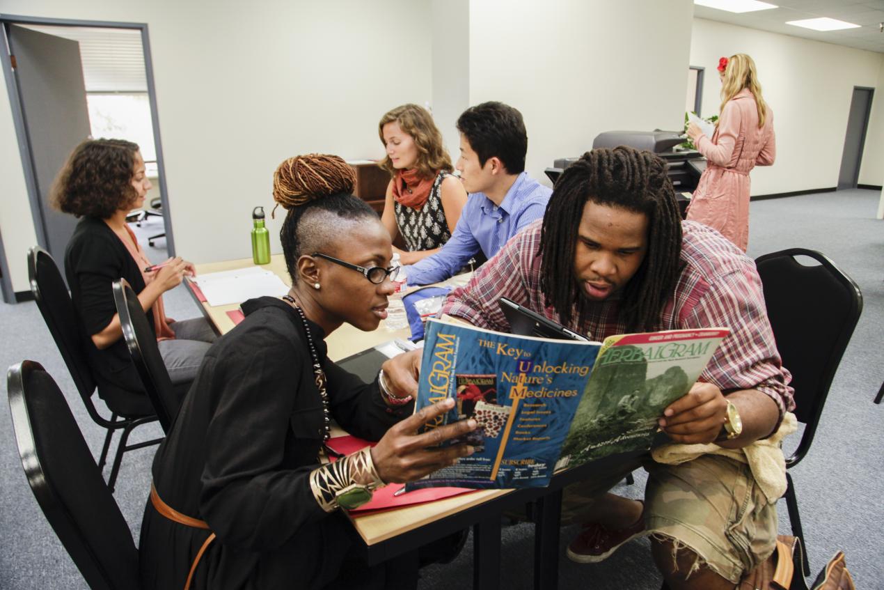 two students looking at book together